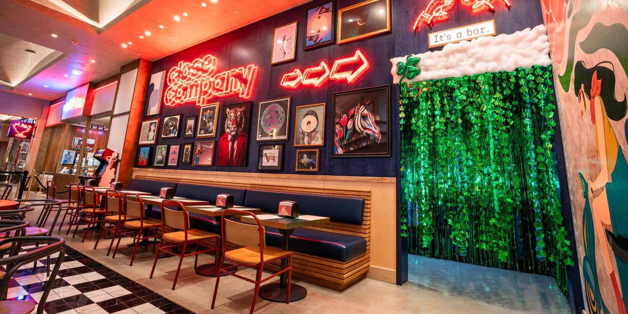 Colorful bar entrance with neon signs and a green themed entryway.