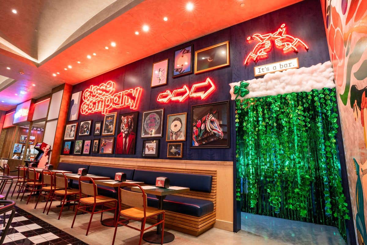 Colorful bar entrance with neon signs and a green themed entryway.