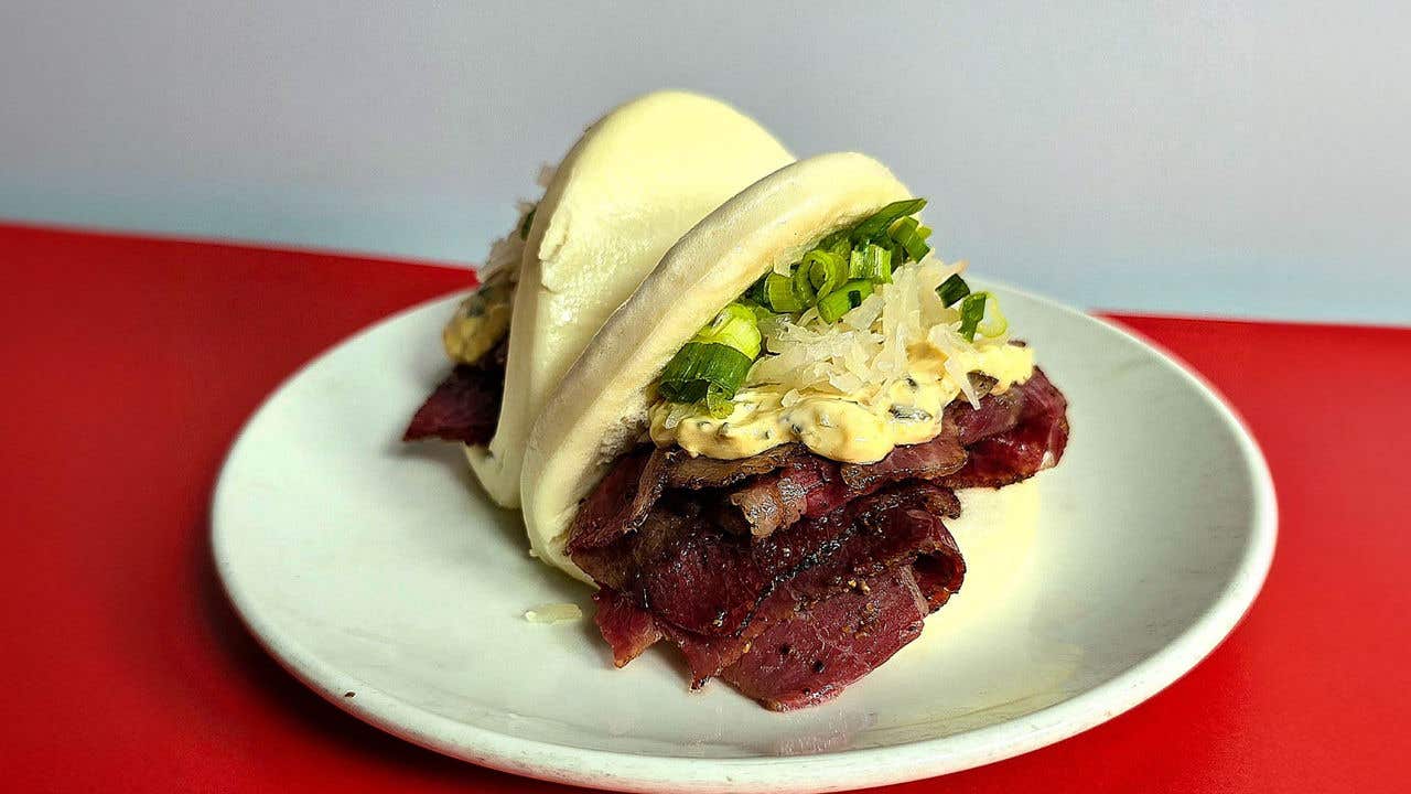 Pastrami with dressing in a steamed bun. 